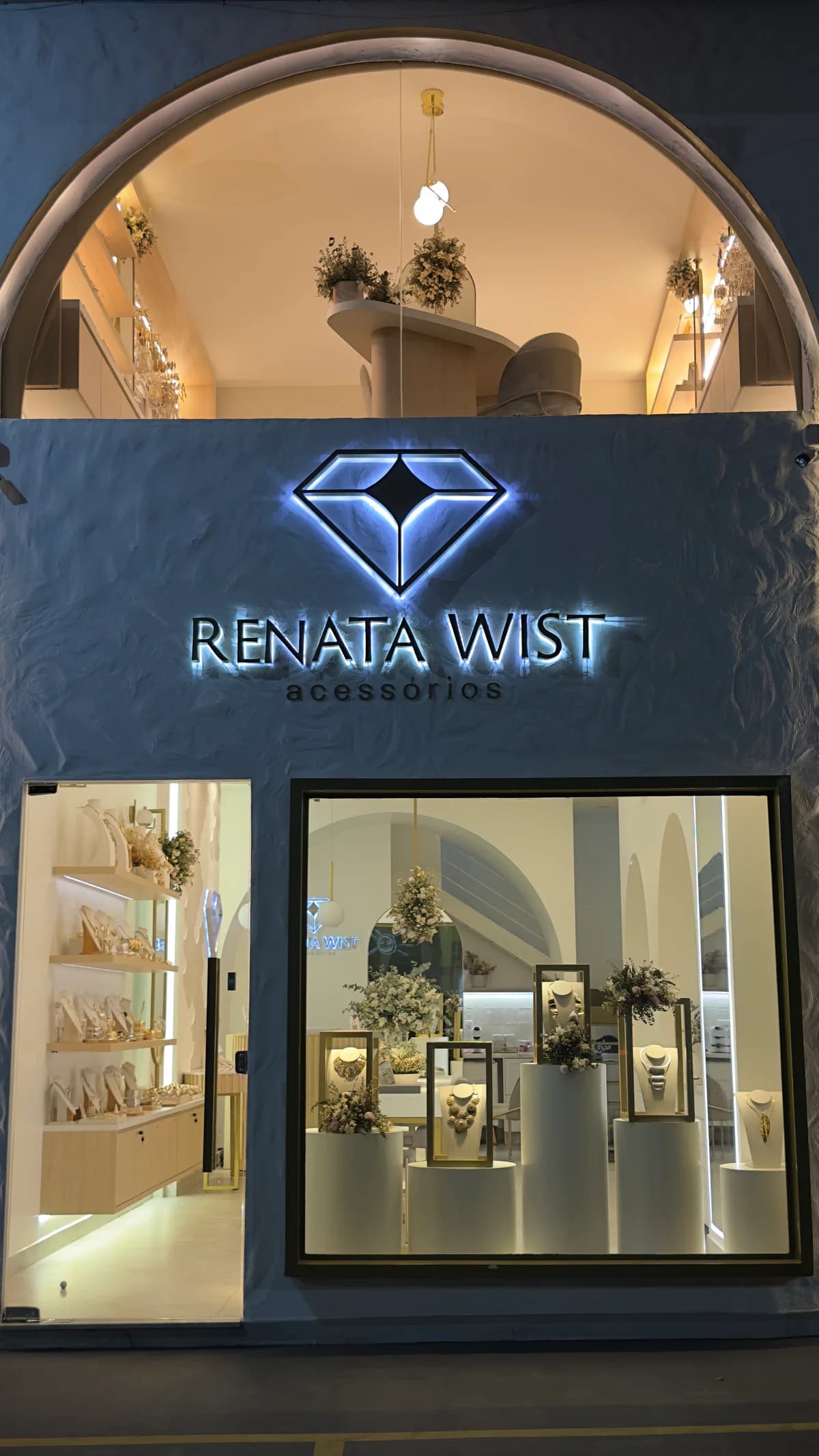 Fachada atualizada da loja Renata Wist com letreiro e vitrine iluminada